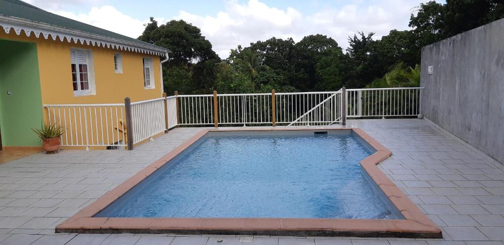 a swimming pool on a patio next to a house at La créola BAYALOCATION in Rivière-Pilote