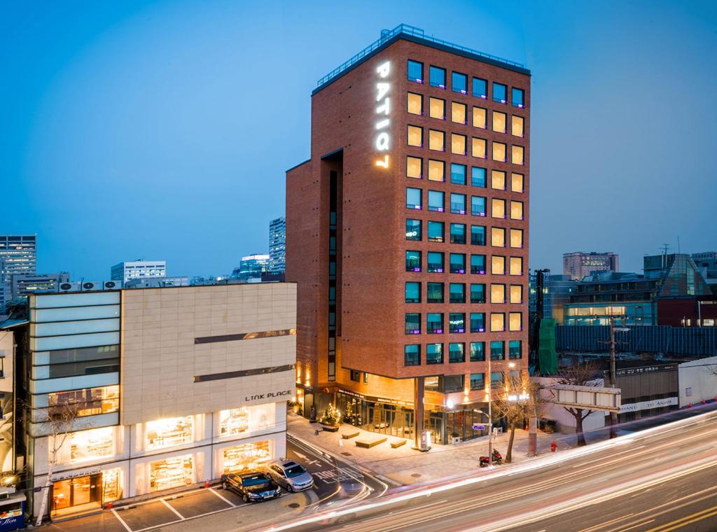 um edifício alto numa rua da cidade à noite em Patio 7 em Seul