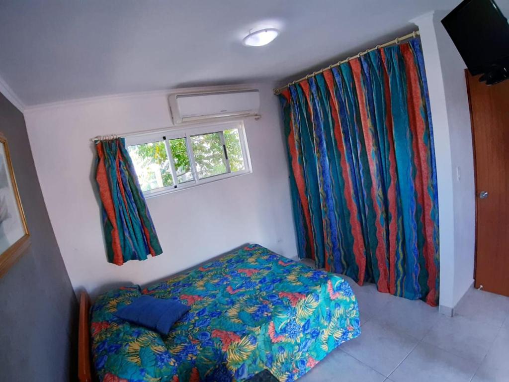 a small bedroom with a bed and a window at Tropical Studio Apartment in Palm-Eagle Beach