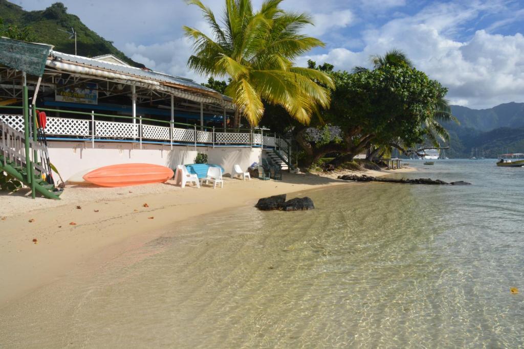 a beach with two chairs and a building at Fare Maheata in Pihaena