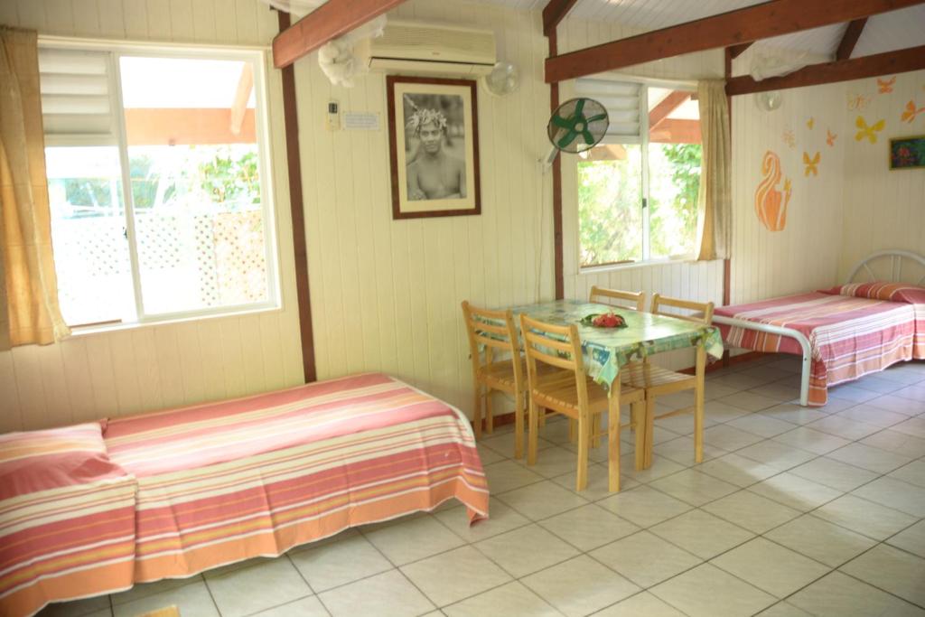 a room with a table and a table and chairs at Fare Maheata in Pihaena