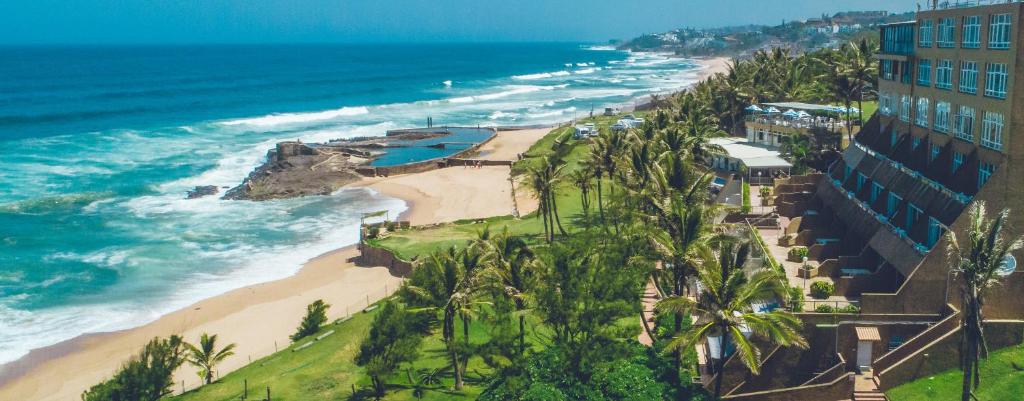an aerial view of a beach with palm trees and the ocean at Salt Rock Hotel and Beach Resort in Ballito
