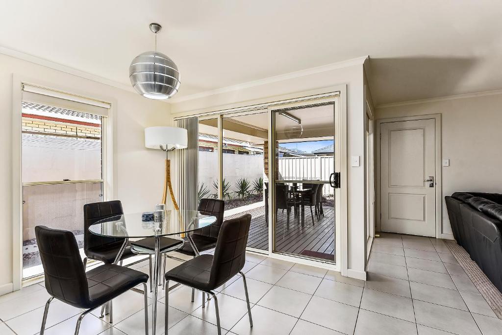 a dining room with a glass table and chairs at City Fringe Apartment in Mount Gambier
