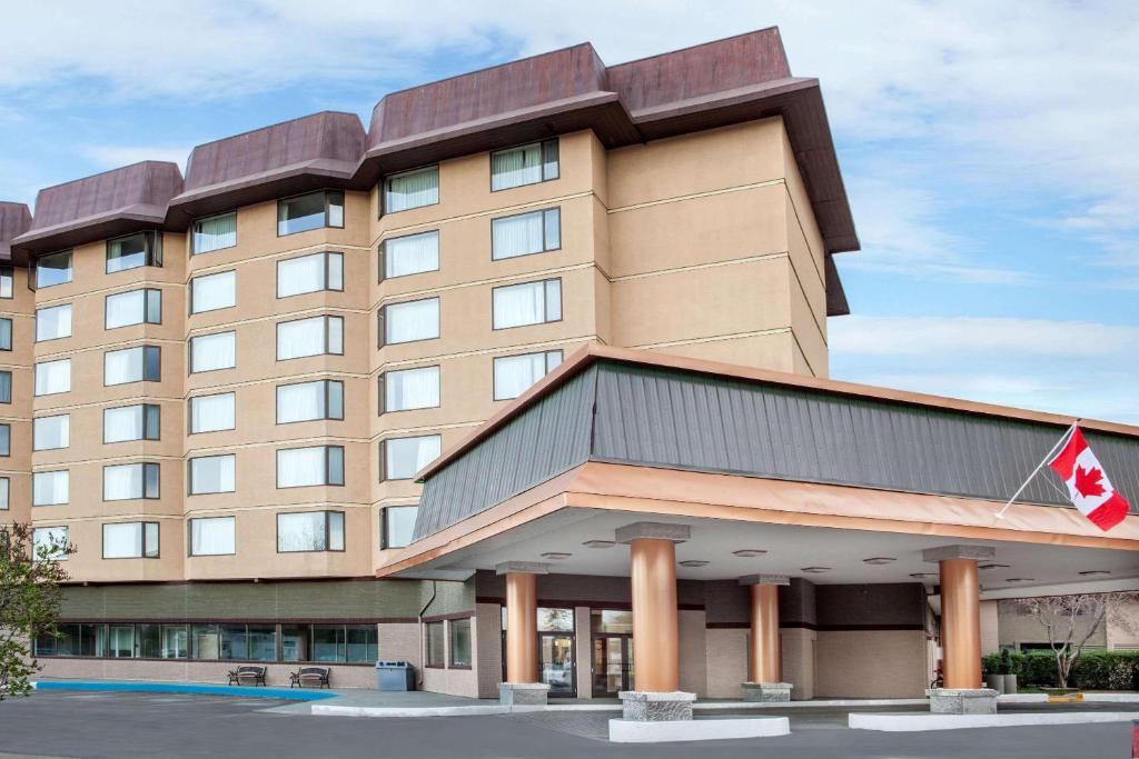 a hotel with a canadian flag on top of it at Baymont by Wyndham Red Deer in Red Deer