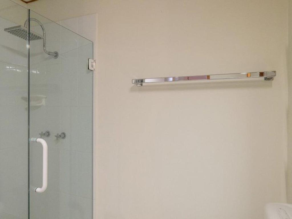 a bathroom with a shower with a glass door at Claytons 8 by Discover Stradbroke in Point Lookout