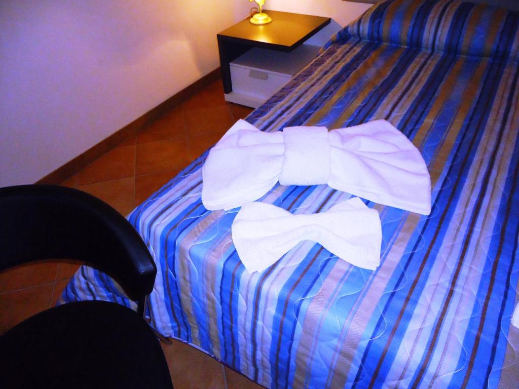 Una cama con una pajarita blanca. en Ciuscia, en Calatabiano