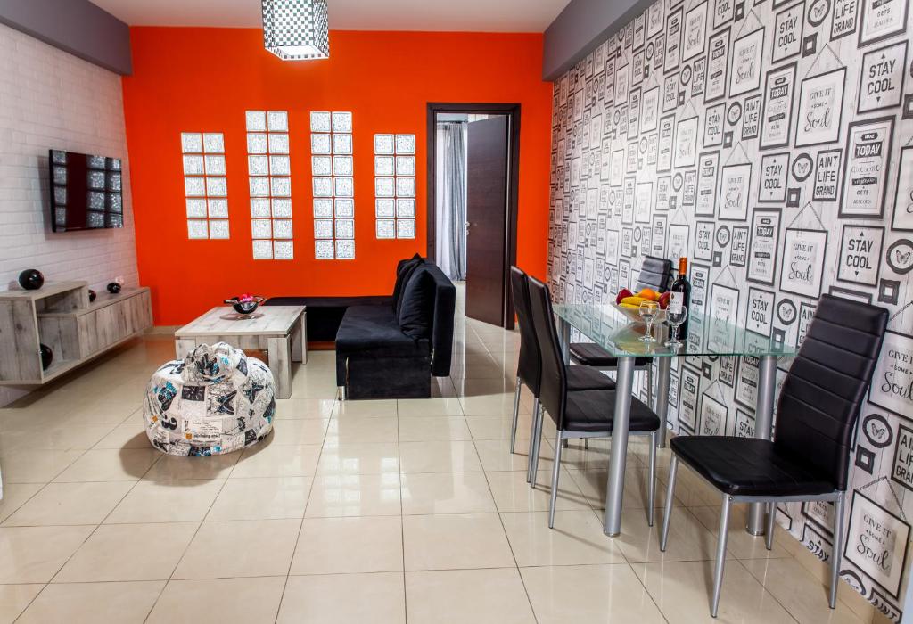 salon z pomarańczowymi ścianami oraz stołem i krzesłami w obiekcie Central Beauty w Jerapetrze