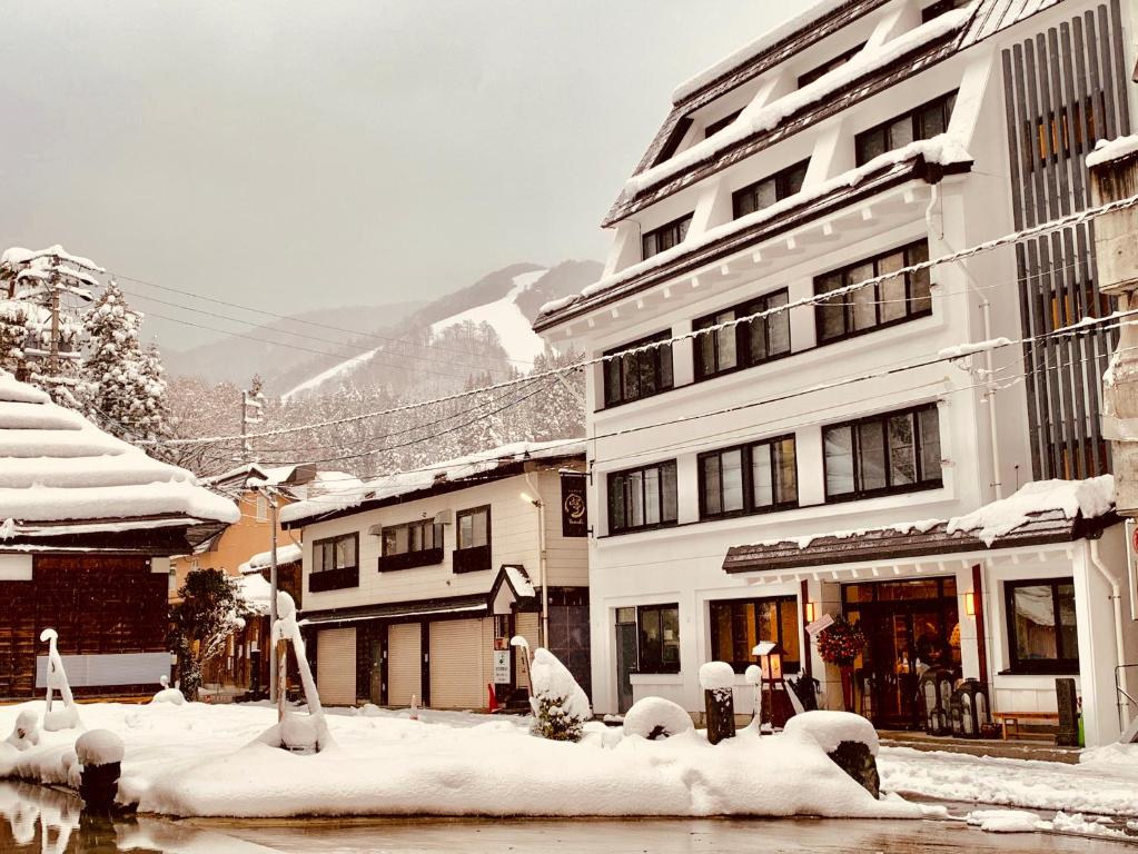 a snow covered street in a city with buildings at Residence Yasushi in Nozawa Onsen