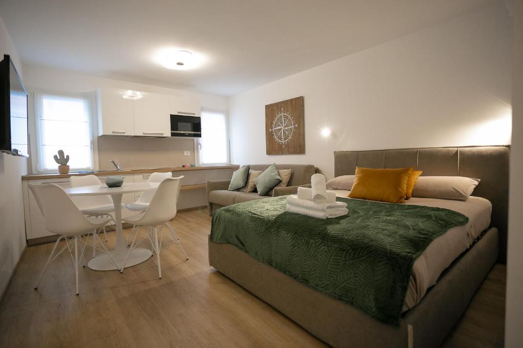 sala de estar con cama, mesa y cocina en Casa Azzurra en Chioggia