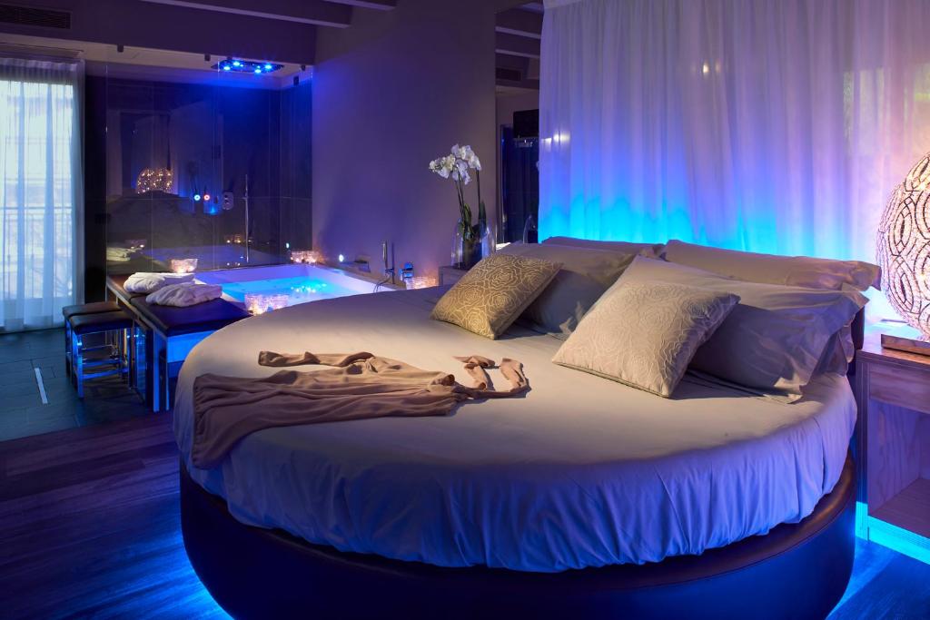 a large bed in a room with blue lights at Hotel Locanda Al Piave ***S in San Donà di Piave