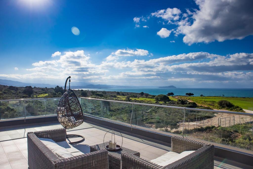 Un balcón con sillas y vistas al océano. en GOLD DREAM HOME en Agios Onoufrios