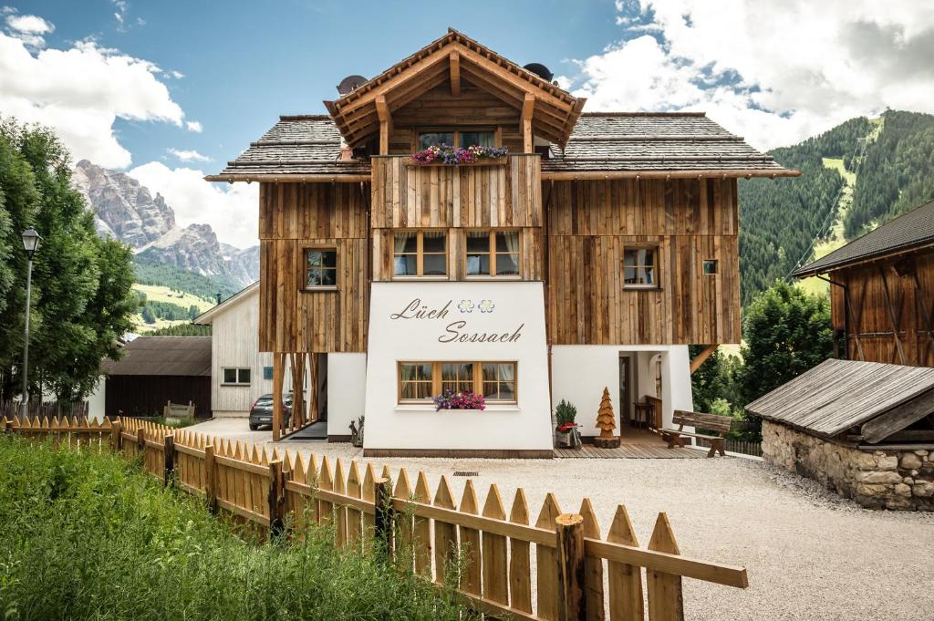 una casa de madera con una valla delante en Natur Luch Sossach, en La Villa