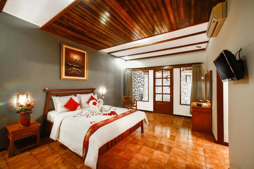 a bedroom with a bed and a television in it at Bali Taman Beach Resort & Spa Lovina in Lovina