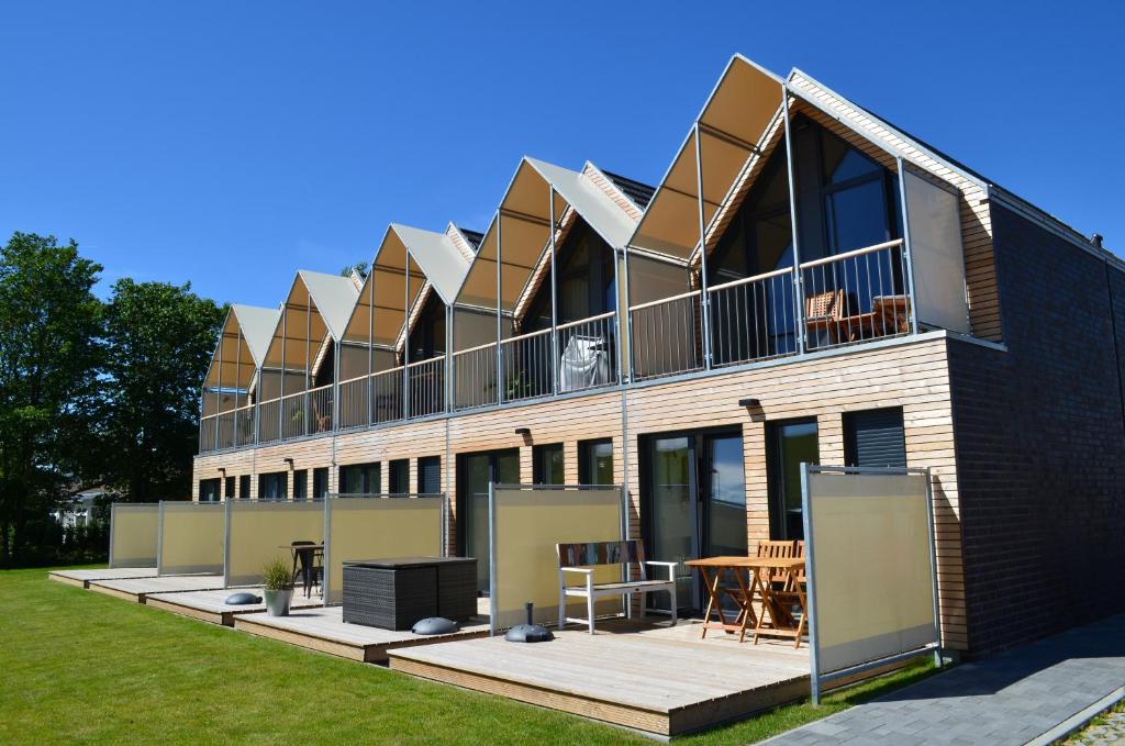 um edifício com uma varanda com uma mesa e cadeiras em Black Pearl em Büsum