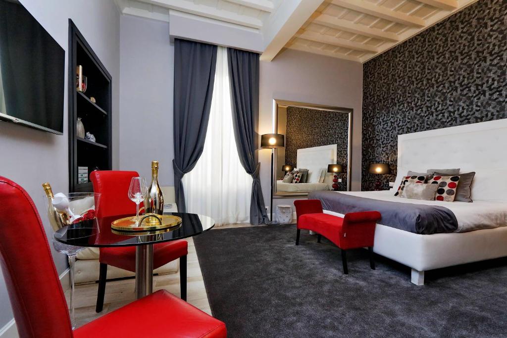 a bedroom with a bed and a table and chairs at Sistina Twentythree luxury rooms in Rome