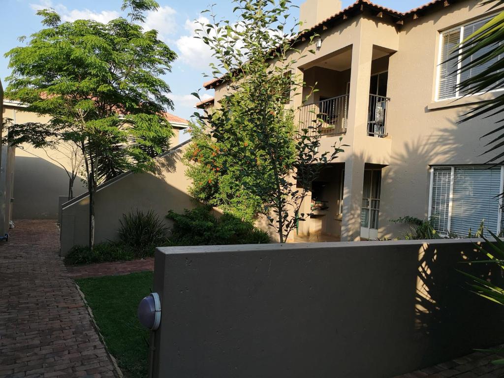 a white house with a fence in front of it at Airport Lodge Guest House in Kempton Park