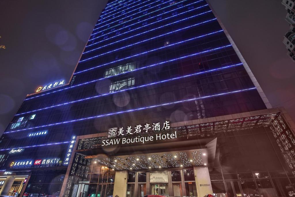 a tall building with a sign in front of it at SSAW Boutique Hotel Wenzhou Jiushan Lake in Wenzhou