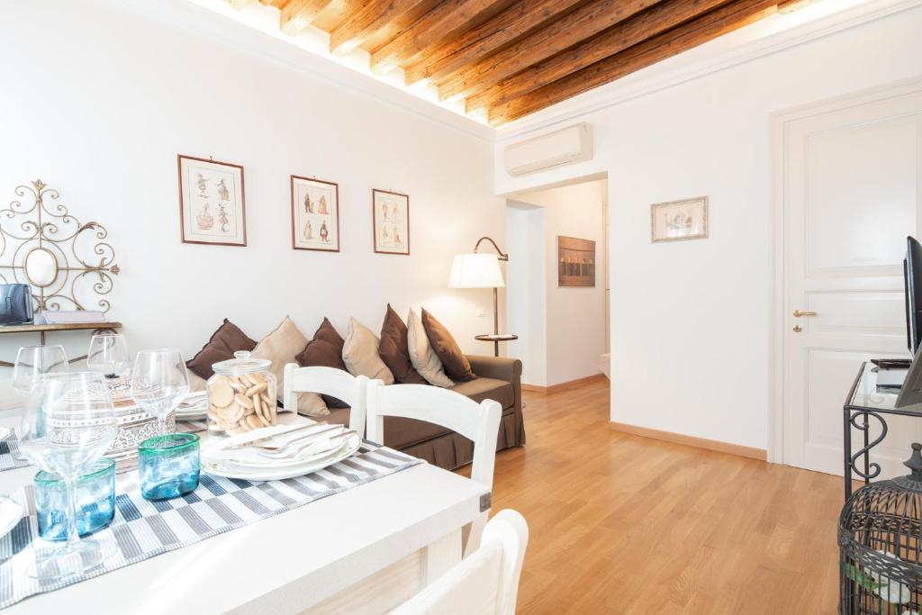 ein Wohnzimmer mit einem Tisch und einem Sofa in der Unterkunft Casa Claudia ai Frari in Venedig