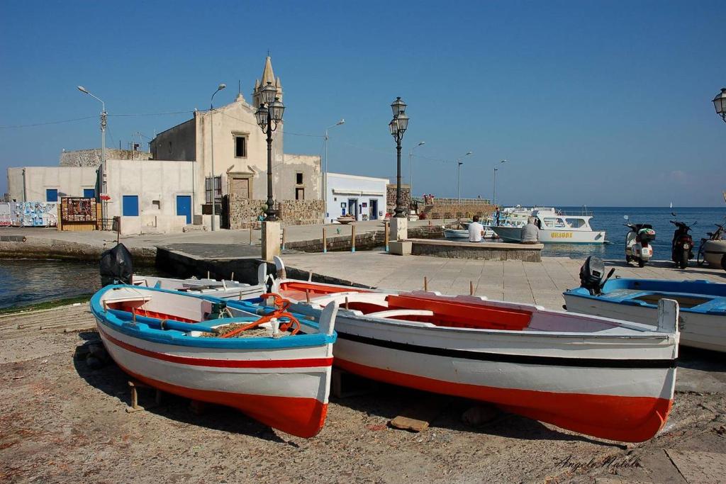two boats sitting on the shore of a dock at Lipari By The Beach in Lipari