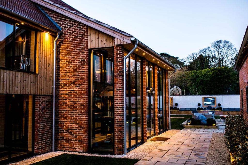 a brick building with large glass windows on it at Baraset Barn Hotel in Stratford-upon-Avon