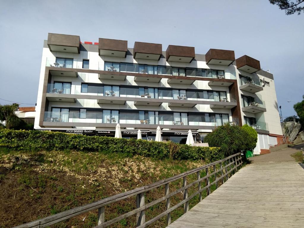 un edificio con balcones al lado de una colina en Hotel Inffinit Sanxenxo, en Sanxenxo