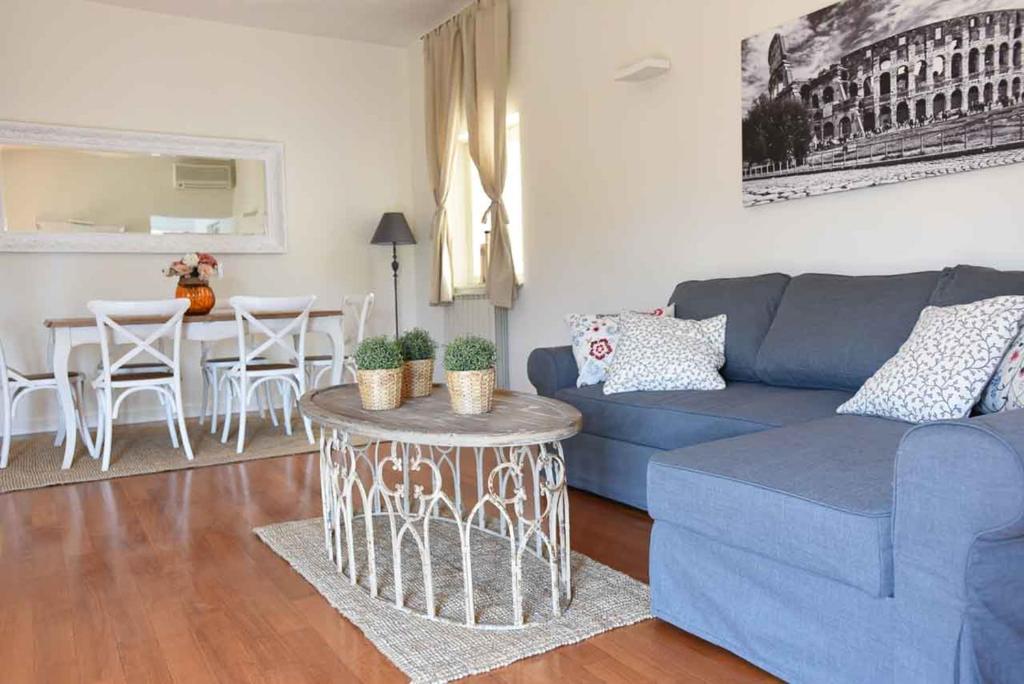 salon z niebieską kanapą i stołem w obiekcie Romantic Flat near Metro Flaminio w Rzymie