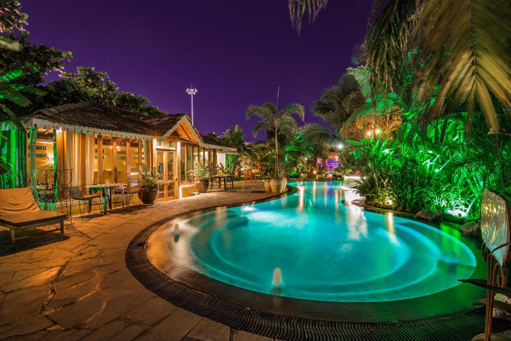 a swimming pool in a resort at night at Fiesta Beach Resort in Baga