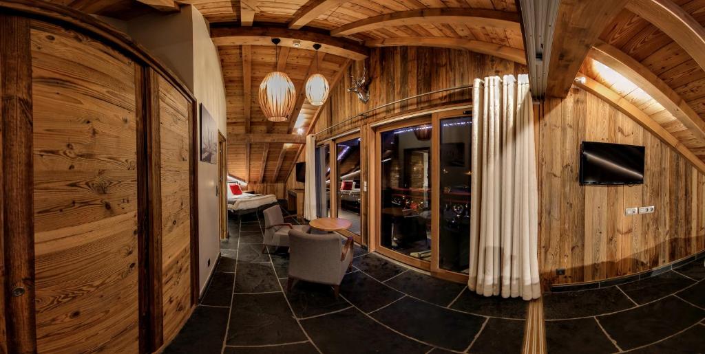 a hallway with wooden walls and a room with a tv at Hôtel Alpina &amp; SPA in Les Gets