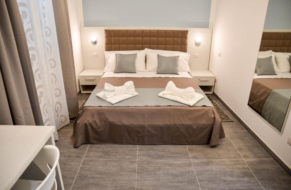 sypialnia z łóżkiem z białymi butami w obiekcie DolceLina Home w mieście Lampedusa