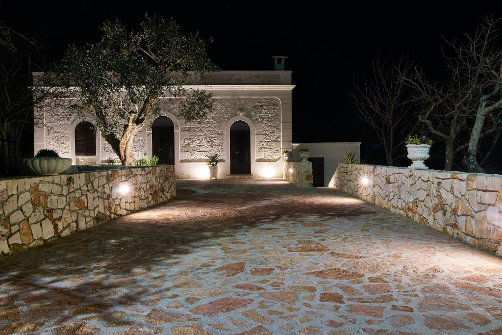 una casa con un muro di pietra di notte di Villa Valentina a Cisternino
