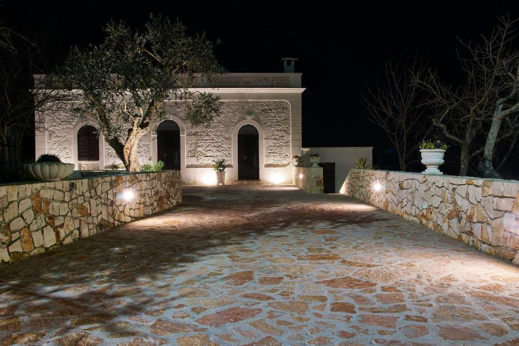 a house with a stone wall at night at Villa Valentina in Cisternino