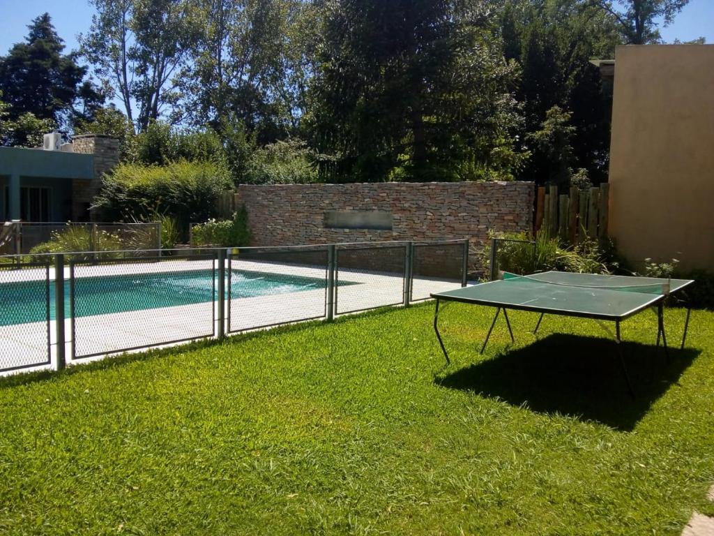 a ping pong table in the grass next to a pool at Los alamos in Chascomús