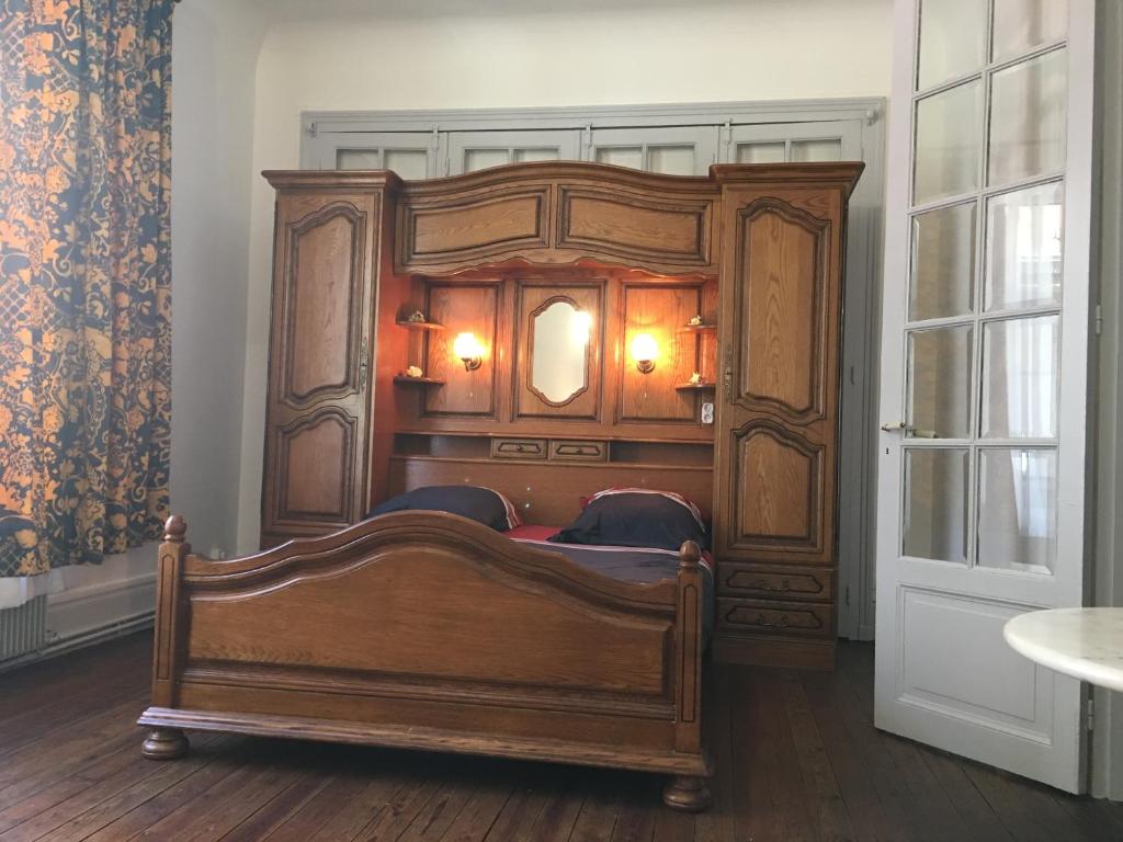 ブローニュ・シュル・メールにあるAux Pieds de La Cathedraleの窓付きの客室で、大きな木製ベッド1台が備わります。