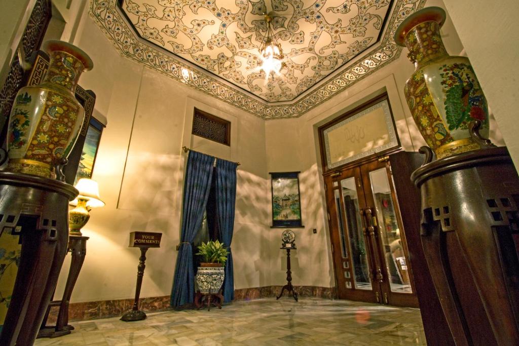 um quarto com um tecto em caixote e um quarto com uma porta em Faisalabad Serena Hotel em Faisalabad
