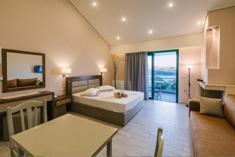 Habitación de hotel con cama y sala de estar. en Giannis Village Resort, en Ástaco