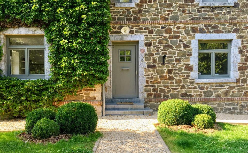 a stone house with a door and two windows at Cottage in Ardennes - La Maison aux Moineaux - Fays-Famenne in Sohier