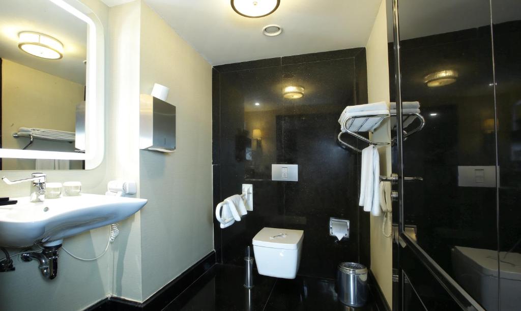 a bathroom with a sink and a toilet and a mirror at Latanya Hotel Ankara in Ankara