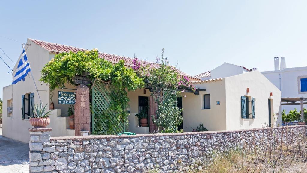 a house with a stone wall and a fence at Koralia Apartments in Kýthira