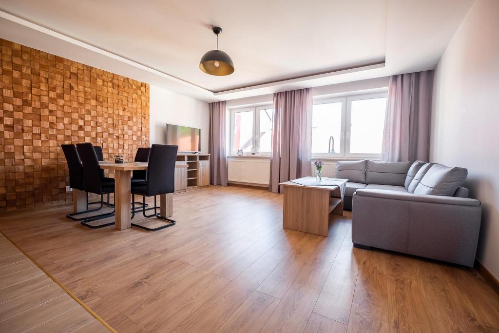 een woonkamer met een bank en een tafel bij Apartament Loft in Augustów