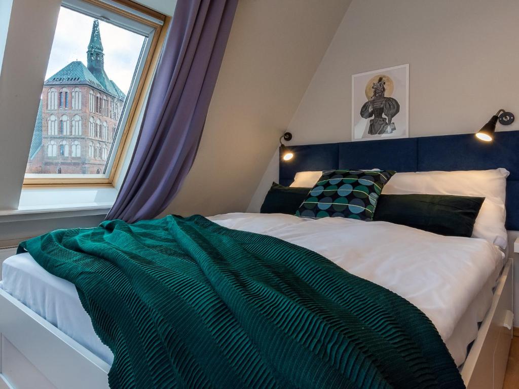 a bedroom with a bed with a large window at VacationClub - Armii Krajowej Apartament 10 in Kołobrzeg