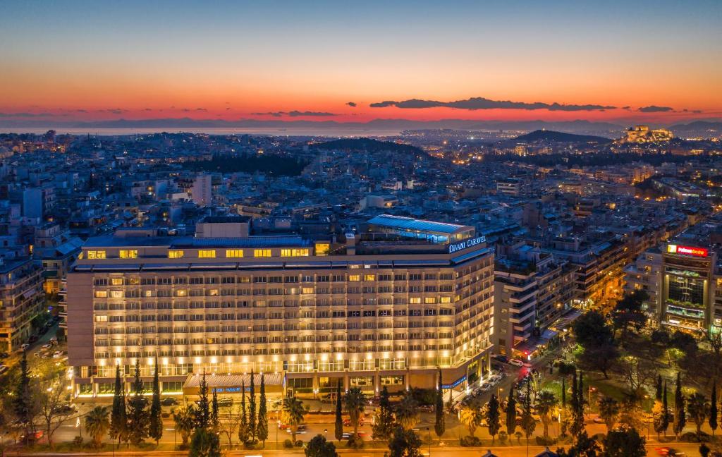 a view of a building with a city at night at Divani Caravel in Athens