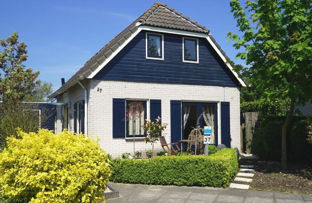 een blauw-wit huis met een raam bij Noordzeepark Zuiderdiep 37 - Ouddorp near the beach - not for companies in Ouddorp
