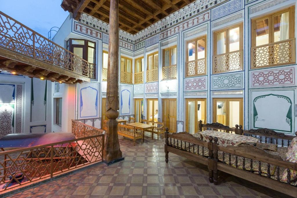 a large room with two beds and a staircase at Basilic Boutique Hotel in Bukhara