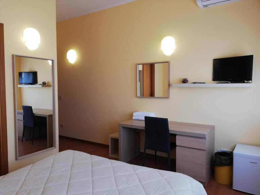 Dormitorio con cama, escritorio y TV en Albergo Roma, en Lanciano
