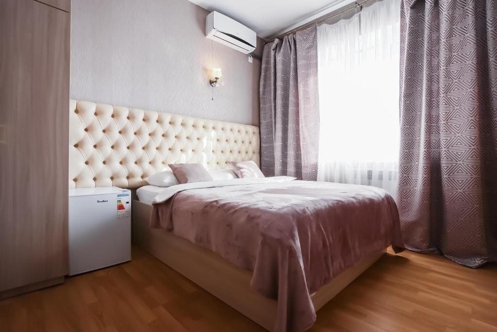 ロストフ・ナ・ドヌにあるMini-Hotel Granatのベッドルーム1室(大きなベッド1台、大きな窓付)