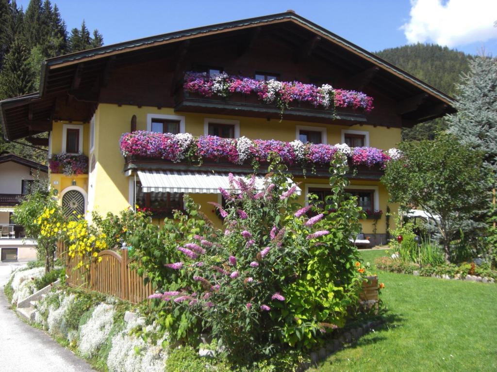 a house with flowers on the side of it at Haus am Bach in Wagrain