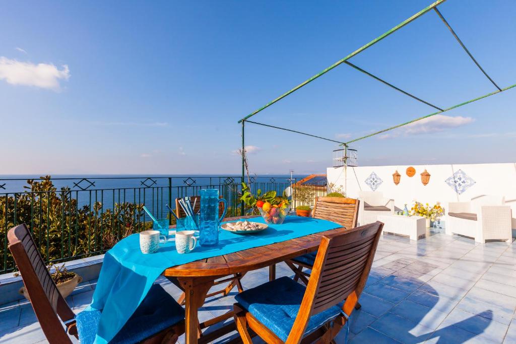 un tavolo e sedie su un balcone con vista sull'oceano di Isabella Massalubrense a Massa Lubrense