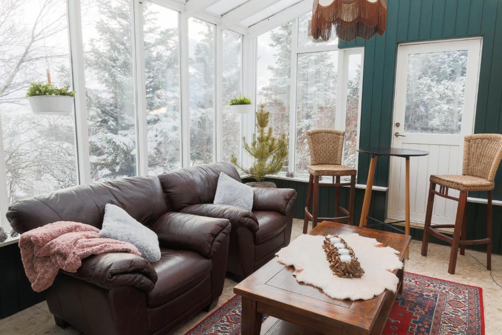 a living room with a leather couch and a table at The apartment - Öbbuhús in Borgarnes