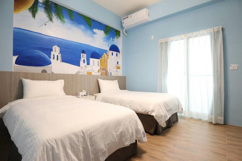 une chambre avec deux lits et un tableau au mur dans l'établissement 蘑菇村一津宿囍民宿, à Taïtung