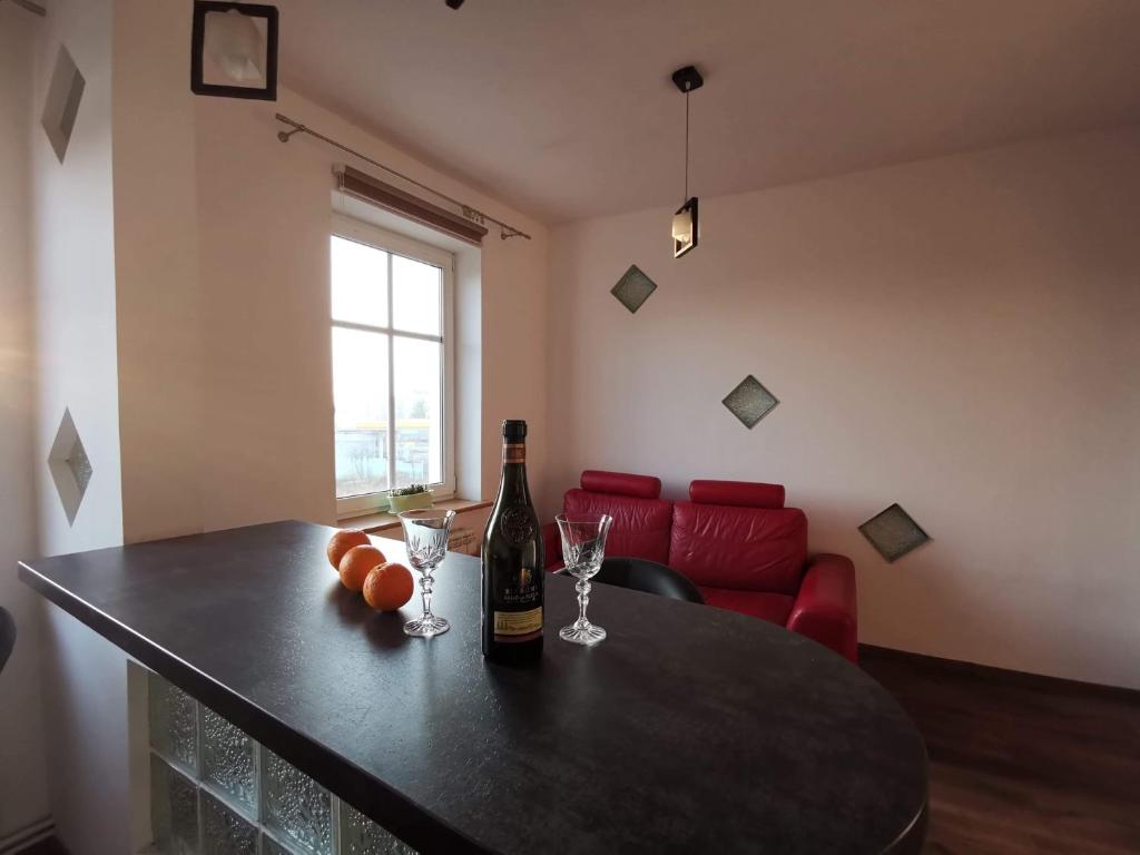 a room with a table with a bottle of wine and glasses at Apartament Rodzinny S7 in Kalisz